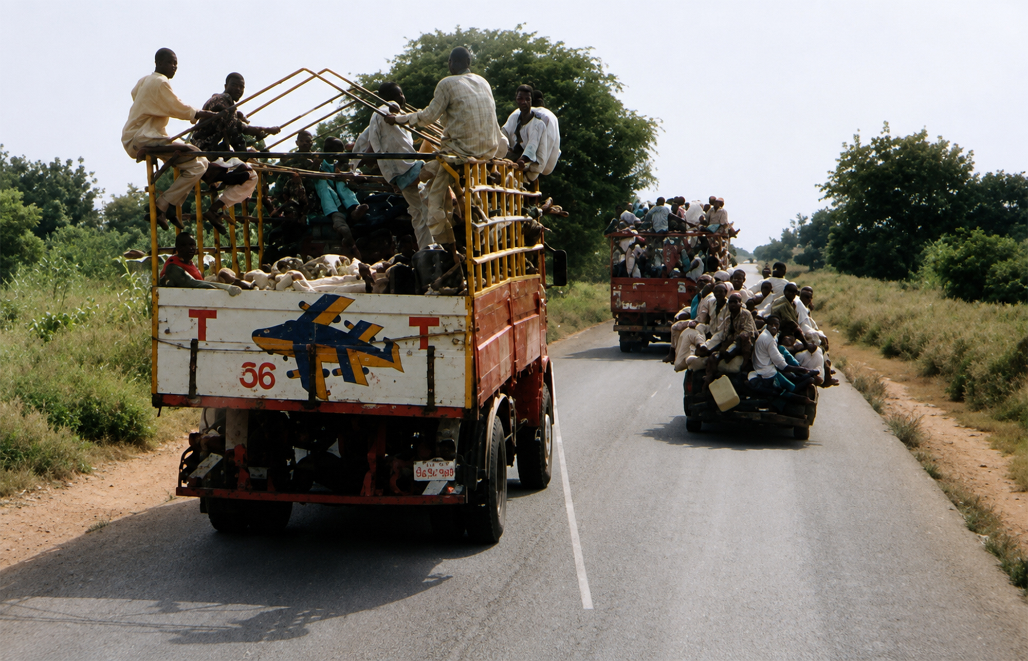 Camiones cargados de pasajeros y ganado circulando por una carretera rural cerca de Jos durante la Travesía Nigeriana