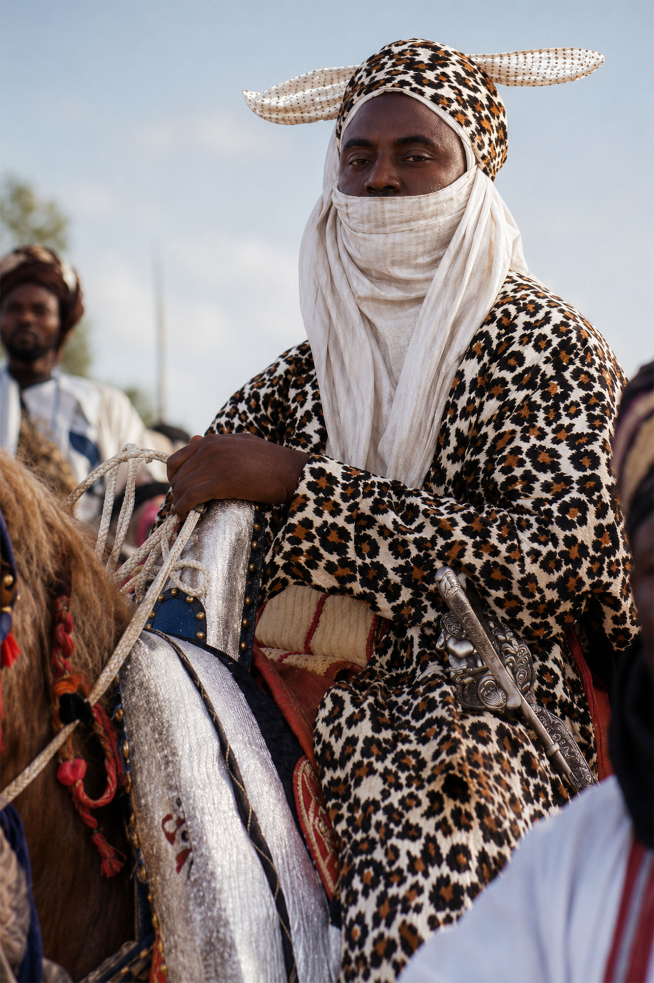Jinete con turbante y túnica de estampado leopardo montado durante una ceremonia en Kano durante la Travesía Nigeriana