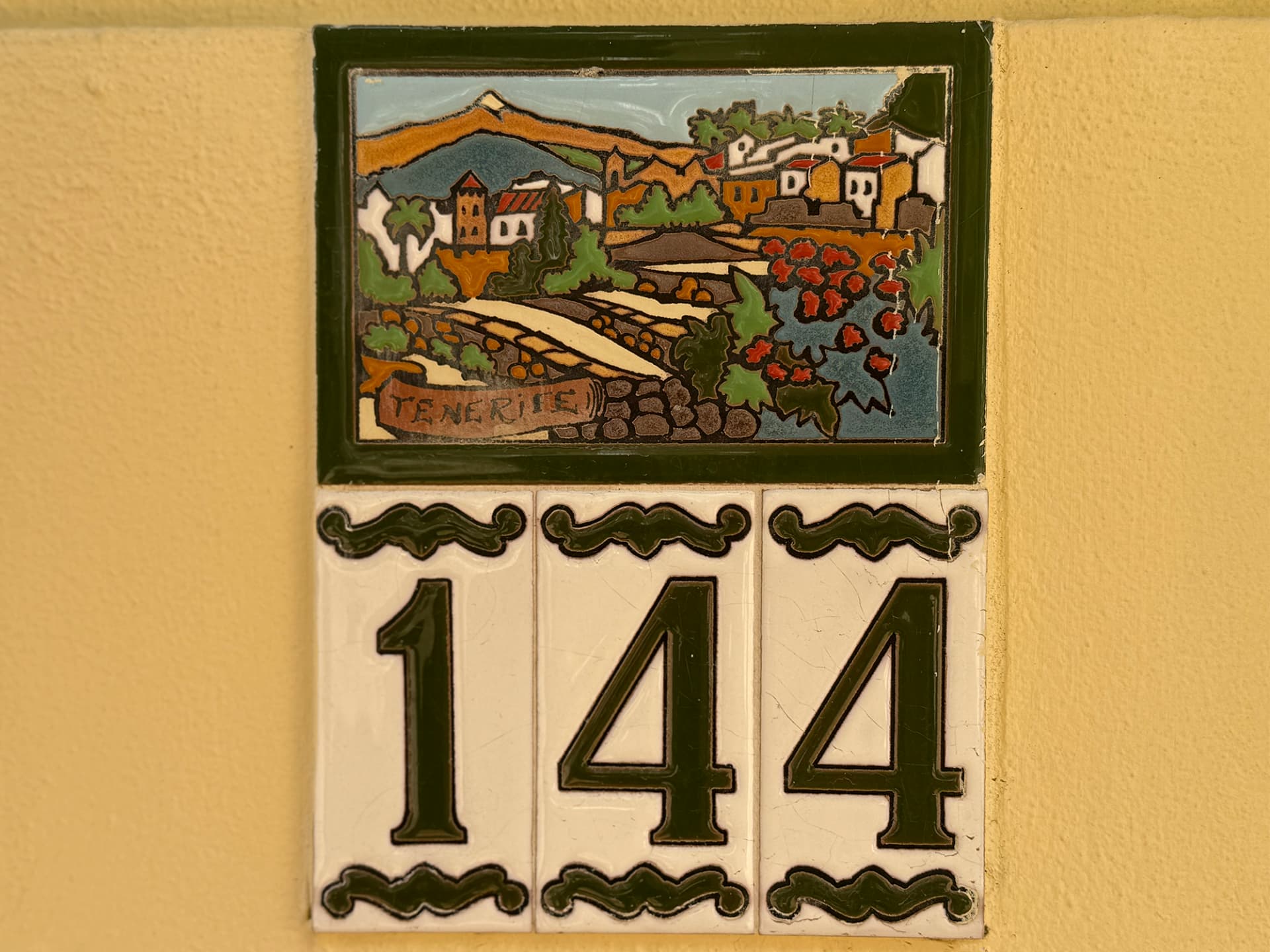 Detalle de una placa de cerámica de Tenerife junto al número 144