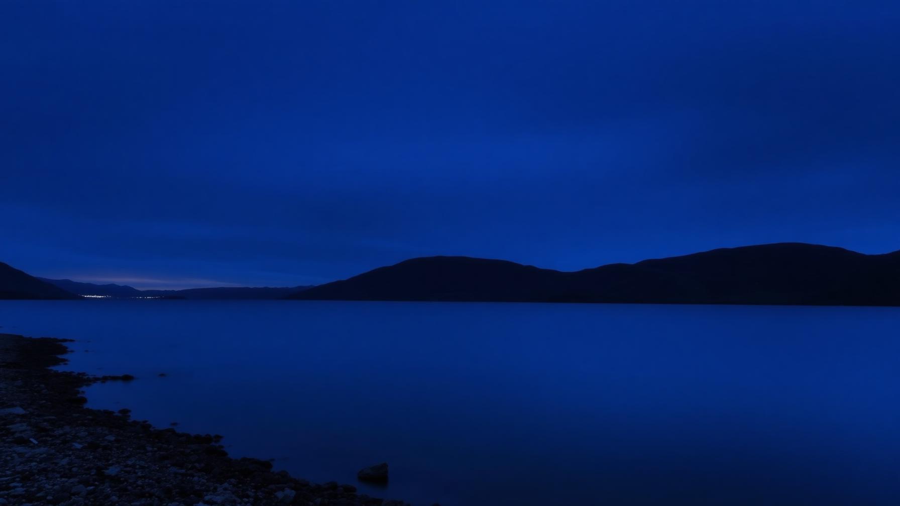 Lago de las Highlands al anochecer con las colinas en silueta