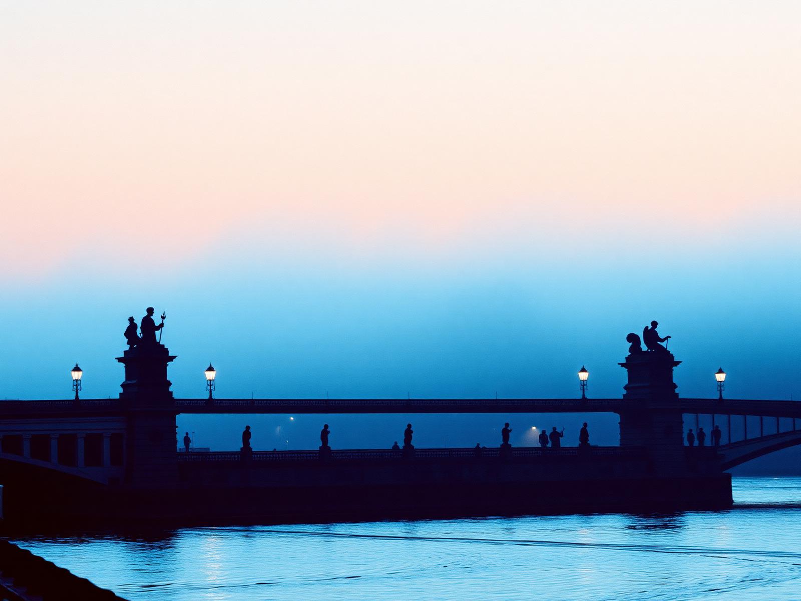 Puente histórico sobre el río Moldava en Praga con estatuas y farolas al amanecer entre la niebla